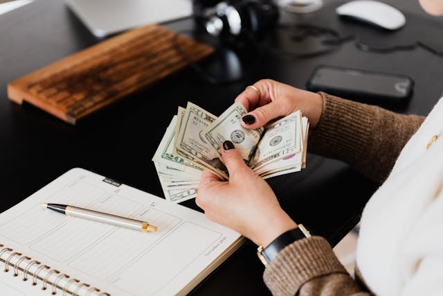 A woman counting dollar bills