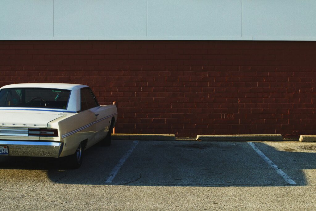 Parked car and empty parking spot near the wall
